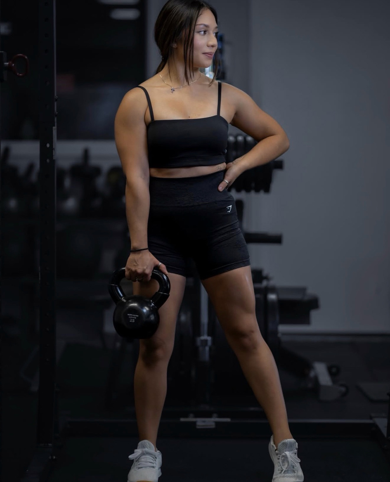 Trainer holding a kettlebell in a gym.